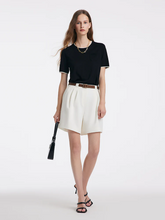 a lady in white bermuda shorts with black t-shirt